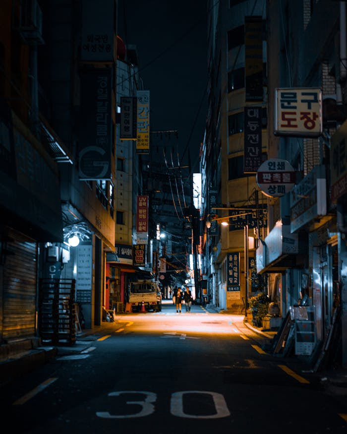 A vibrant Seoul street at night, illuminated with neon signs and a bustling urban atmosphere.