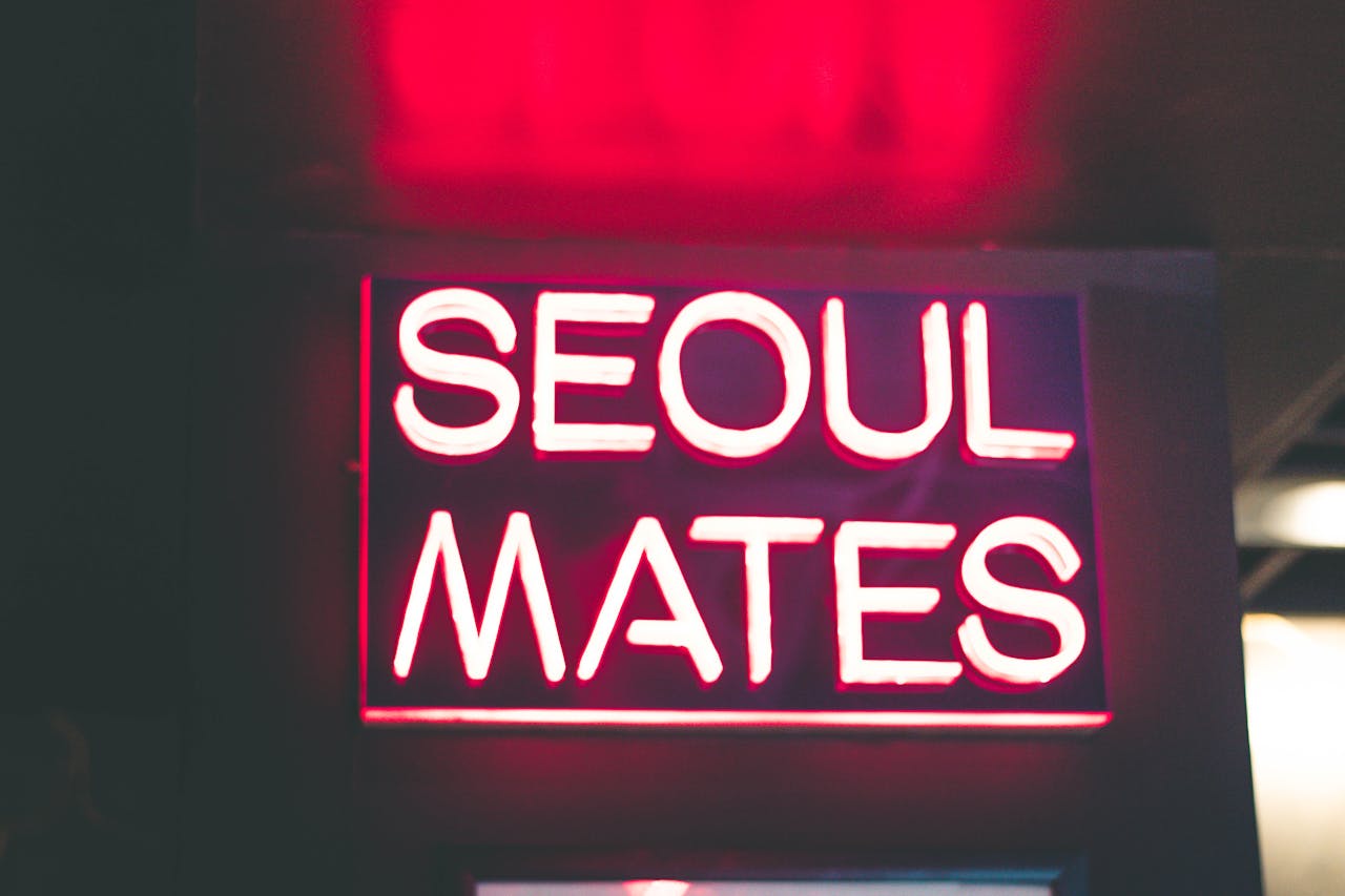 Vibrant pink neon sign reading 'Seoul Mates' glowing in the dark. Perfect for nightlife and design themes.